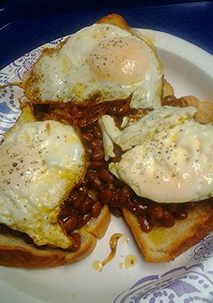 A picture of Baked beans on toast with egg.
