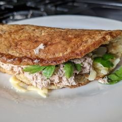 A picture of Oat omelette with cheese and Tuna salad.