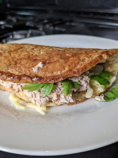 A picture of Oat omelette with cheese and Tuna salad.