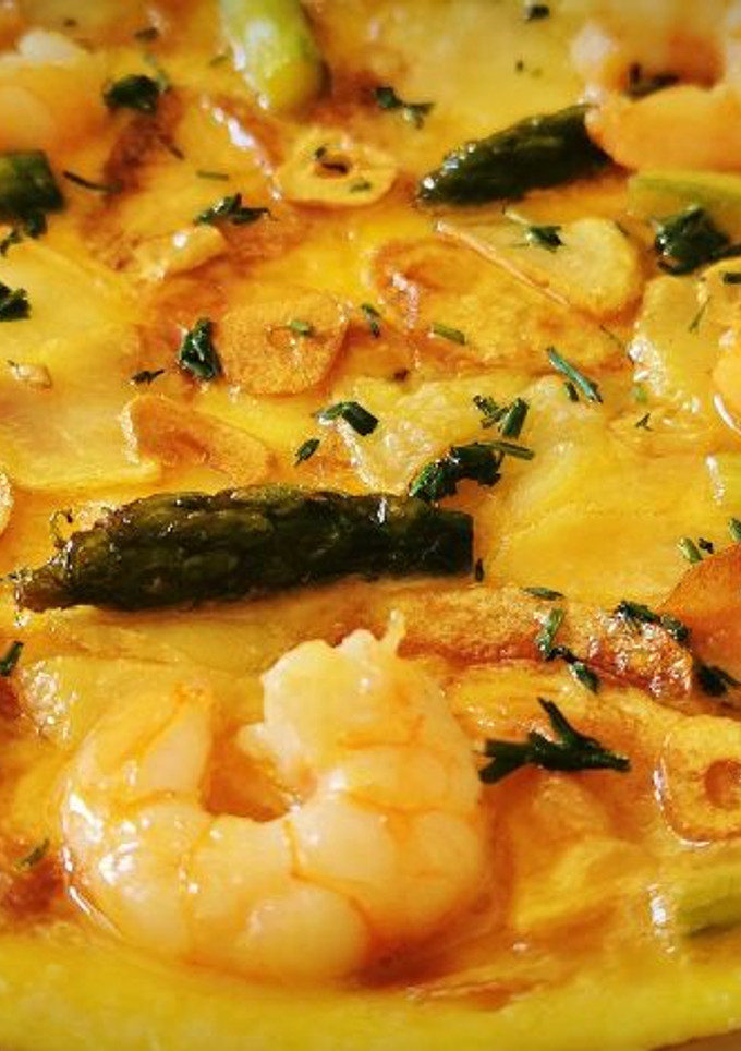 Una foto de Tortilla abierta con Patatas fritas, Espárragos y Langostinos