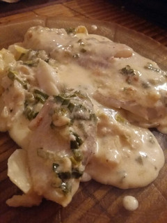 Una foto de Filet de merluza en colchón de papas con salsa crema roquefort