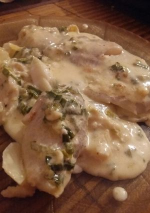 Una foto de Filet de merluza en colchón de papas con salsa crema roquefort