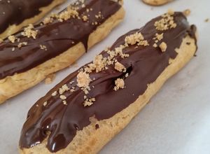 Una foto de Eclairs sin Gluten Rellenas de Crema Pastelera y Coulis de Fresas con Cobertura de Chocolate