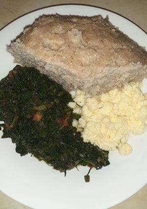 A picture of Scrumbled eggs, spinach and brown ugali.