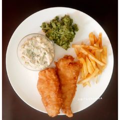 A picture of English style Fish and Chips with Mushy Peas and Tartar Sauce.