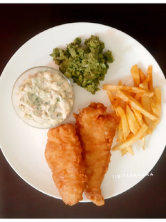 A picture of English style Fish and Chips with Mushy Peas and Tartar Sauce.