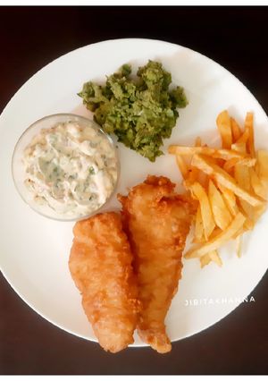 A picture of English style Fish and Chips with Mushy Peas and Tartar Sauce.