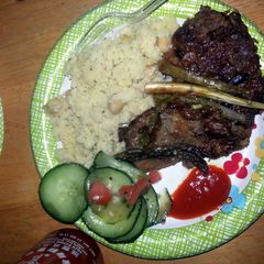 A picture of smoothered steak with asapragus sprouts.