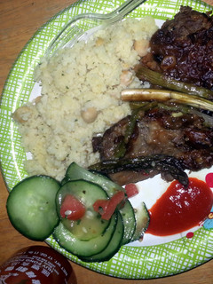 A picture of smoothered steak with asapragus sprouts.