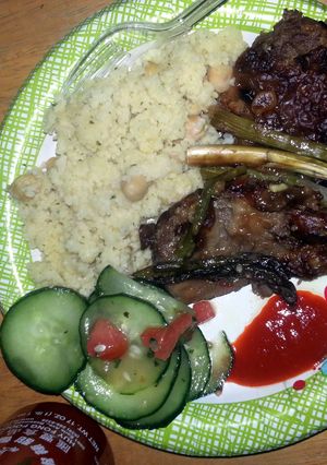 A picture of smoothered steak with asapragus sprouts.
