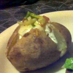 A picture of baked potatoe with guacamole.