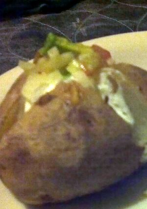 A picture of baked potatoe with guacamole.