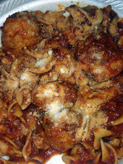 A picture of egg noodles with sauce and chicken meatballs.