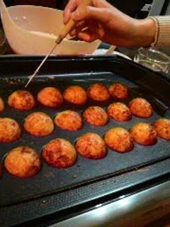 A picture of Perfectly Round Takoyaki With Crisp Outsides and Creamy Insides.