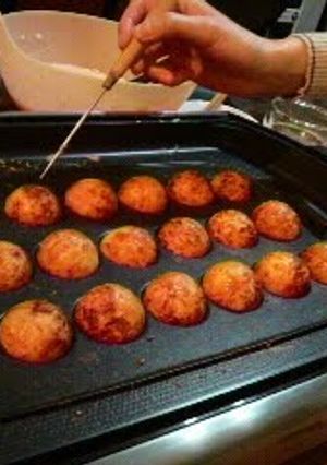 A picture of Perfectly Round Takoyaki With Crisp Outsides and Creamy Insides.