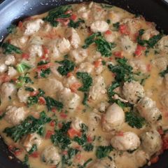 A picture of Sausage with Tomatoes & Kale in Cheddar Cheese Sauce.
