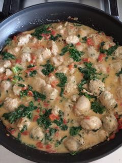 A picture of Sausage with Tomatoes & Kale in Cheddar Cheese Sauce.