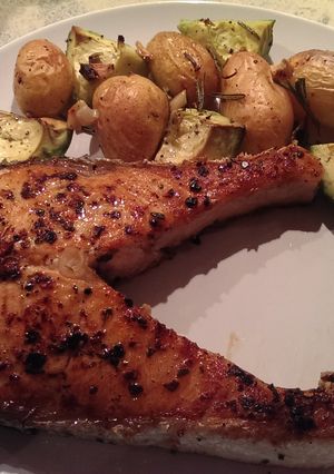 A picture of Peri peri salmon with roasted rosemary potatoes and avocados.