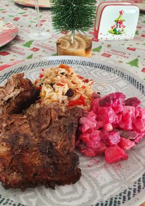 Una foto de Costillas a la parrilla con arroz navideño y ensalada Rusa