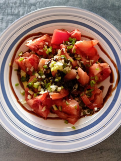 Una foto de Ensalada de tomate rosa, cebolleta, pimiento verde y calabacín