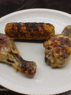 Una foto de Jamoncitos de pollo con mazorcas de maíz al grill doble
