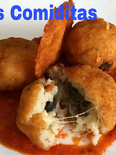 Una foto de Arancini con berenjena, salsa napolitana y teja de queso parmesano+
