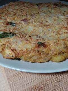 Una foto de 🥚Tortilla de patata 🥔con cebolla 🧅 tomate en aceite 🍅 y albahaca 🌿
