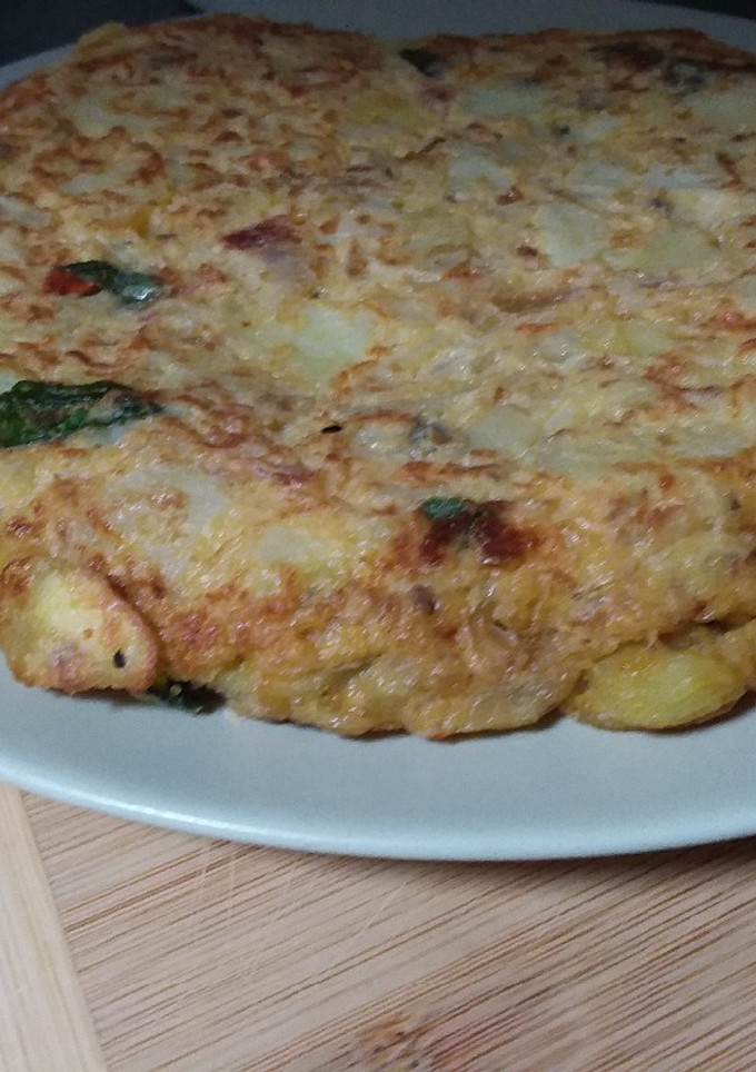 Una foto de 🥚Tortilla de patata 🥔con cebolla 🧅 tomate en aceite 🍅 y albahaca 🌿