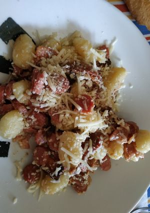 Una foto de Ñoquis con bacon, salchichas y salsa de queso