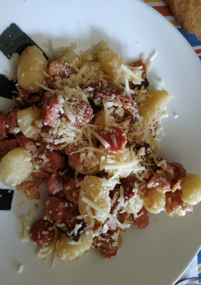 Una foto de Ñoquis con bacon, salchichas y salsa de queso