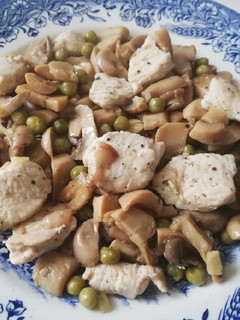 Una foto de Pechuga de pollo con champiñones al ajillo y guisantes