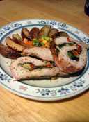 spinach and pepper stuffed pork loin with parmesan potato wedges and mixed veggies