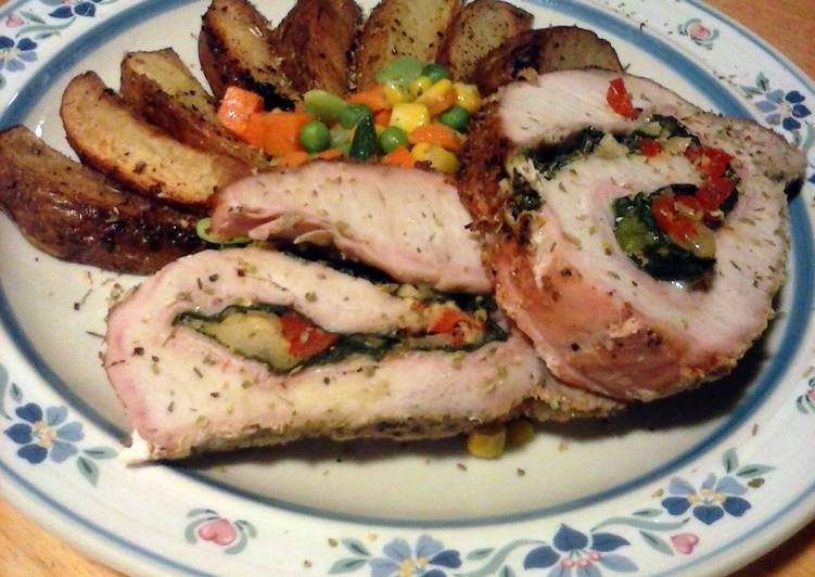 Delicious spinach and pepper stuffed pork loin with parmesan potato wedges and mixed veggies