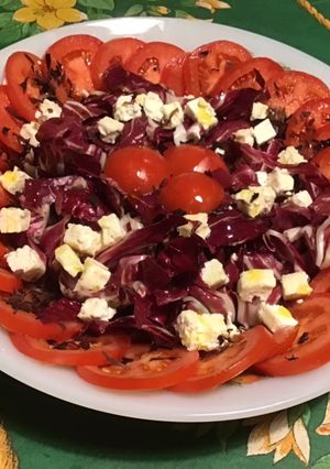 Une photo de Salade de tomates, trevisana, feta et dulce sauce olive, ciboulette