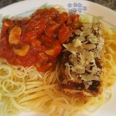 A picture of Tofu parm with mushroom marinara sauce, angel hair pasta.