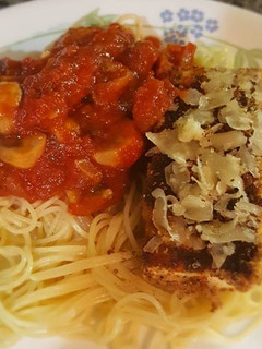 A picture of Tofu parm with mushroom marinara sauce, angel hair pasta.