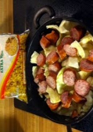 A picture of Fried cabbage and noodles with kielbasa.