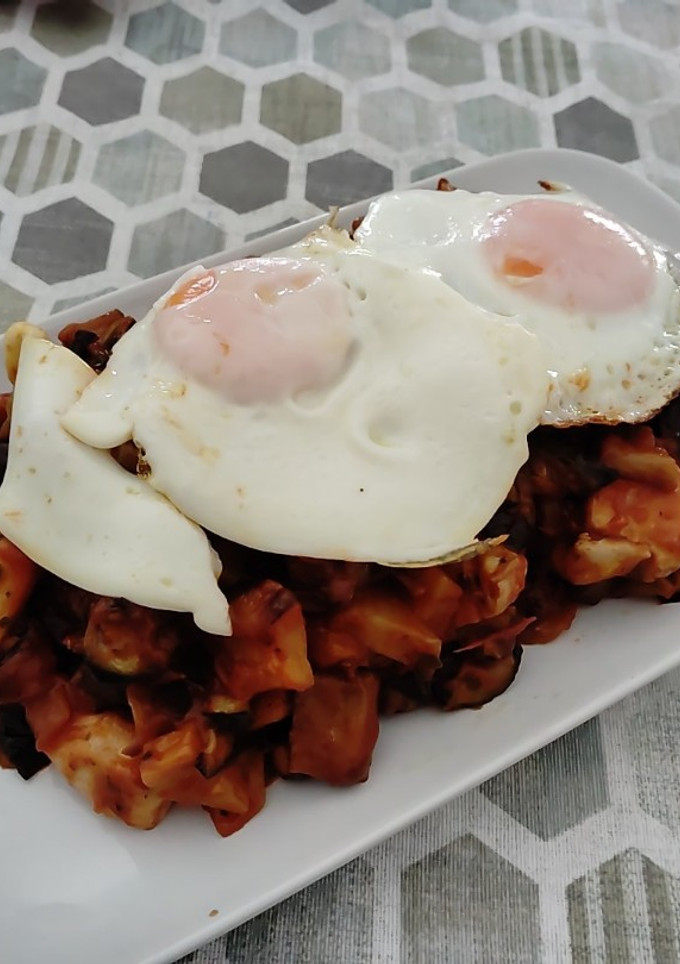 Una foto de Pisto con pechuga marinada y huevo y tomate natural