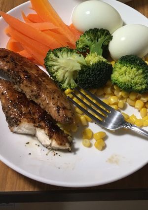 A picture of Fried chicken breast on boiled veggies.
