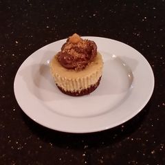 A picture of Peanut Butter Indivdual Cheesecakes Topped with Chocolate Ganache.
