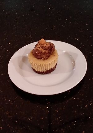 A picture of Peanut Butter Indivdual Cheesecakes Topped with Chocolate Ganache.