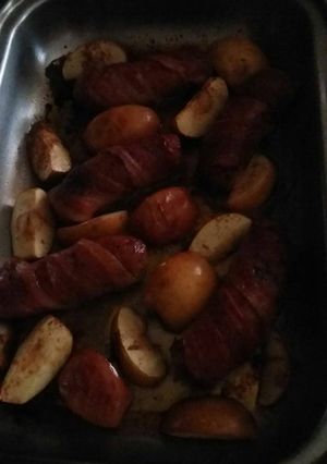 A picture of Bacon wrapped sausage with baked apples.