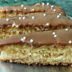 A picture of Coconut Rava cake topped with chocolate and silver balls.
