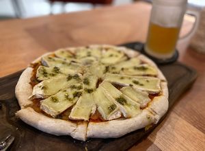 Una foto de Pizza de masa madre con brie y cebollas caramelizadas