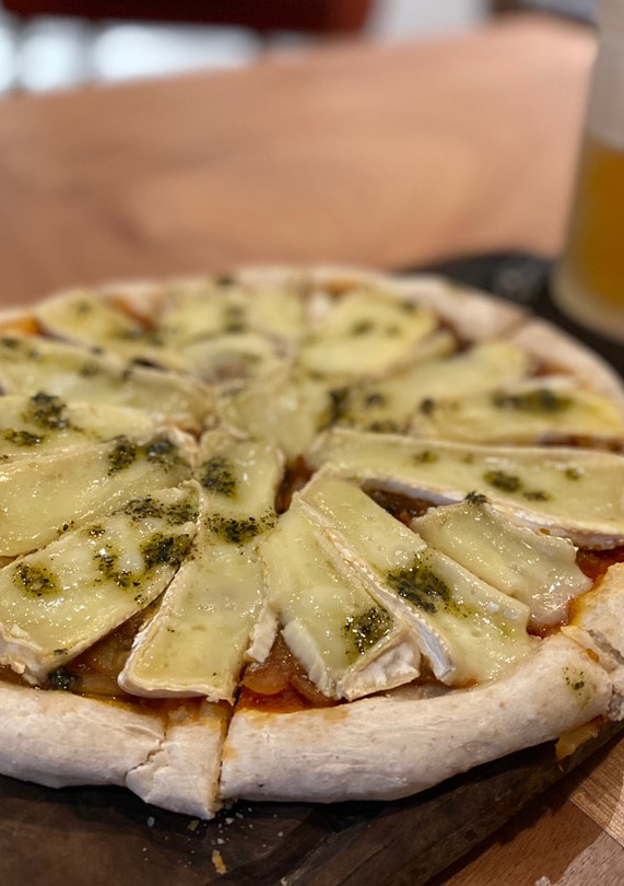 Una foto de Pizza de masa madre con brie y cebollas caramelizadas