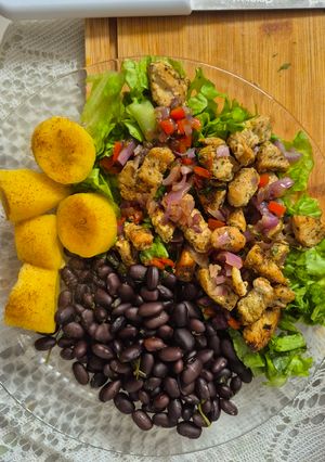 Una foto de Pollo marinado para una ensalada increíble, que acompaña frijoles negros y plátano maduro