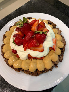 Una foto de Brownie con crema y frutillas
