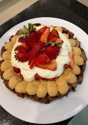 Una foto de Brownie con crema y frutillas