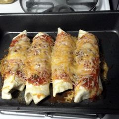 A picture of cheesy chicken enchilada/ burritos.
