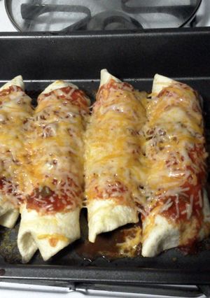 A picture of cheesy chicken enchilada/ burritos.